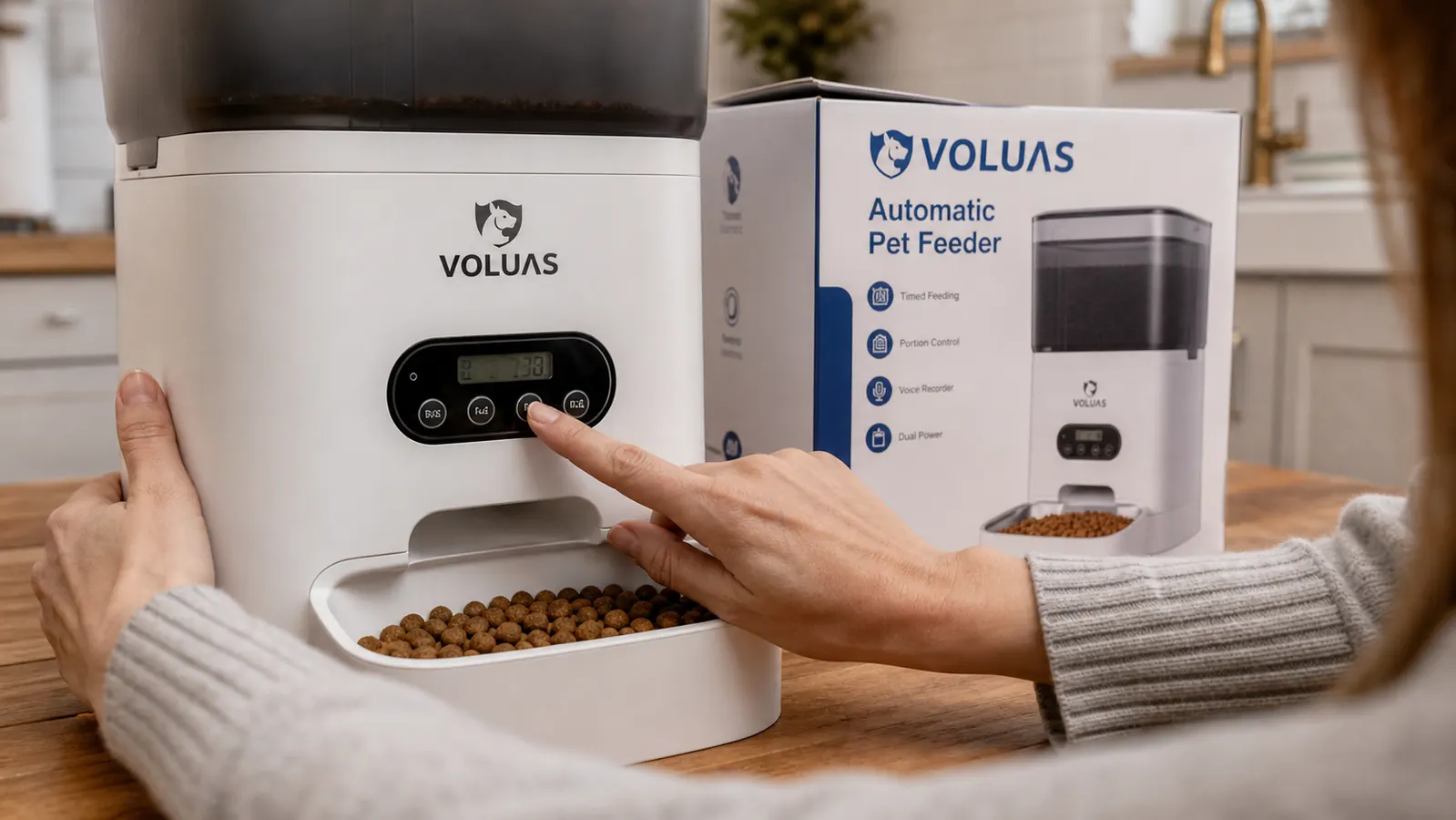 Hand pressing buttons on the VOLUAS automatic pet feeder to program a meal schedule