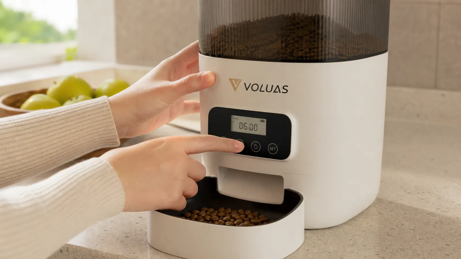 Close-up of hands programming meal times on the VOLUAS feeder control panel